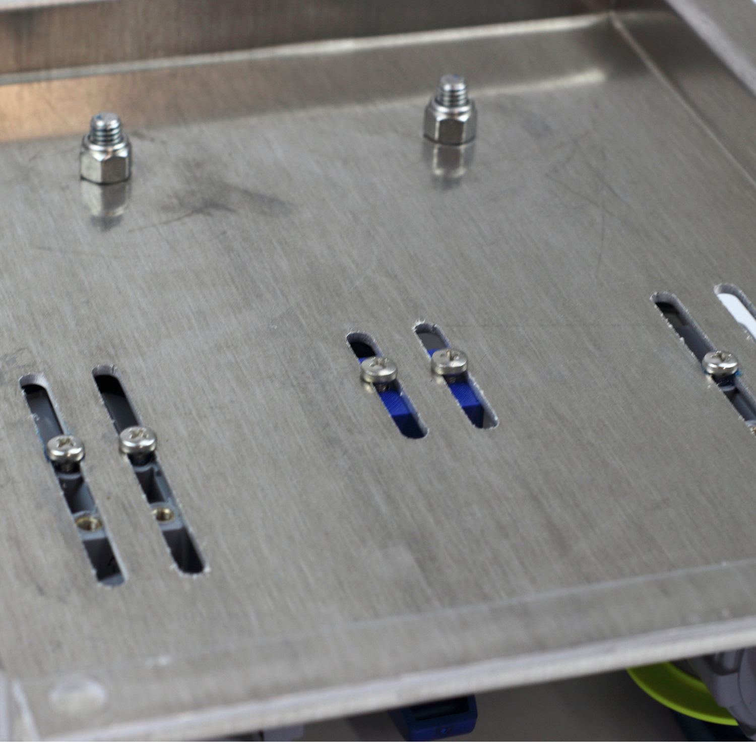 Close-up of mounting plate bolt tracks with partially installed stainless hardware for securing metering valves